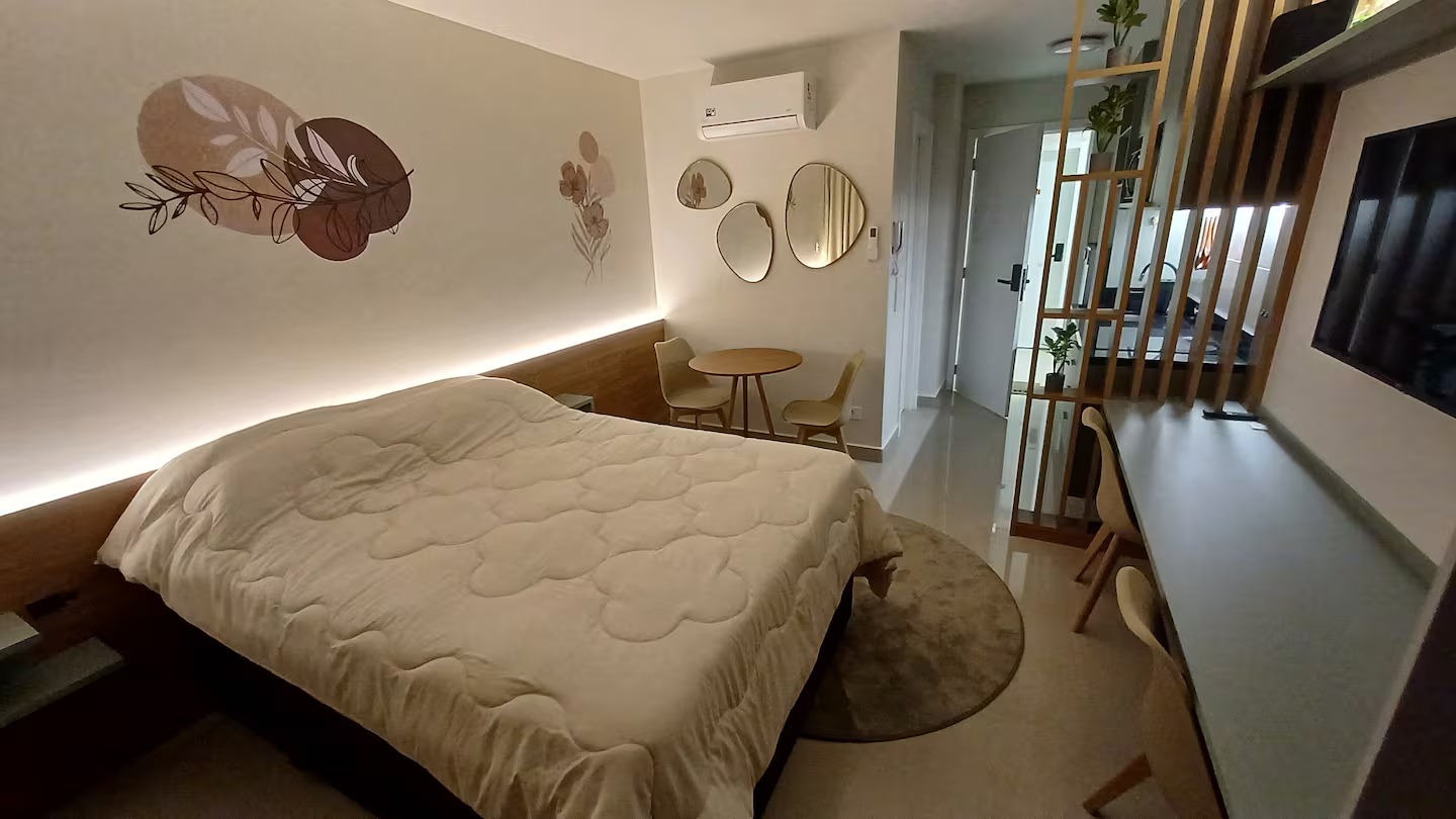 Studio com cama, mesa de jantar e bancada de trabalho integrados